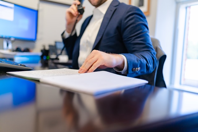Private wealth management advisor reviewing client documents at desk in New England office